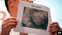 Malaysia's acting Transport Minister Hishamuddin Hussein shows the map of northern search corridor during a press conference at a hotel next to the Kuala Lumpur International Airport, in Sepang, Malaysia, March 17, 2014. 