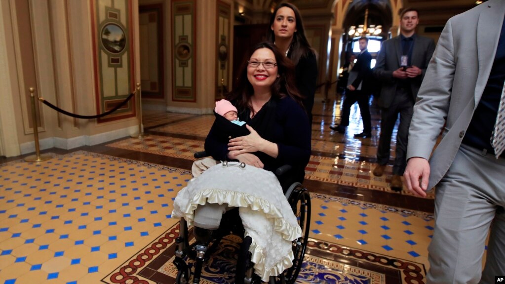 Thượng nghị sĩ Tammy Duckworth bồng con gái sơ sinh Maile Pearl Bowlsbey rời khỏi Thượng viện sau khi biểu quyết trên sàn Thượng viện ở Washington, ngày 19 tháng 4, 2018.
