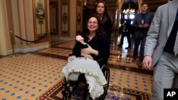 Thượng nghị sĩ Tammy Duckworth bồng con gái sơ sinh Maile Pearl Bowlsbey rời khỏi Thượng viện sau khi biểu quyết trên sàn Thượng viện ở Washington, ngày 19 tháng 4, 2018.