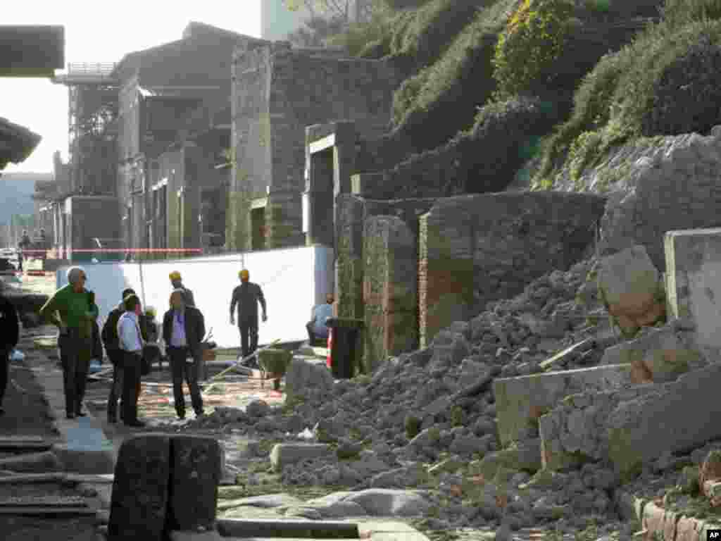 People survey damage from the 2010 collapse of a house used by gladiators in Pompeii. (Reuters)
