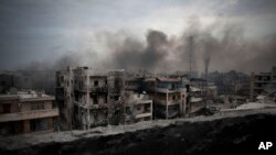 FILE - In this Tuesday, Oct. 2, 2012 file photo, smoke rises over Saif Al Dawla district, in Aleppo, Syria. Residents in the rebel-held districts of Aleppo have a reprieve from the incessant bombings by Syrian government warplanes and the promise of an end to the crippling siege that has left produce stalls bare.