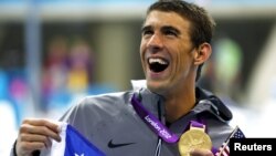 Michael Phelps cầm chiếc huy chương Olympic thứ 19 vừa được trao với thắng lợi trong bộ môn bơi tiếp sức tự do, tiếp sức 4X00 nam
