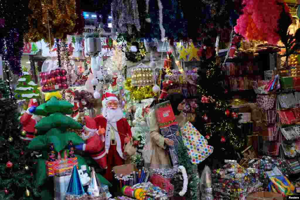 Una mujer sale de una tienda que vende adornos de Navidad y Año Nuevo en Estambul, Turquía.