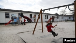 FILE - Children play in a playground at the camp for migrants and refugees in Friedland, Germany, April 4, 2016.