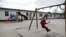 FILE - Children play in a playground at the camp for migrants and refugees in Friedland, Germany, April 4, 2016.