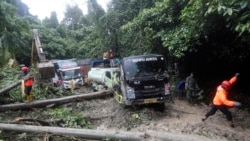 Tim penyelamat membersihkan puing-puing di dekat kendaraan yang terdampak longsor yang menewaskan sejumlah orang di Sibolangit, Sumatera Utara, Kamis, 28 November 2024. (Foto AP/Binsar Bakkara)