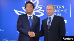 지난 9월 러시아 블라디보스톡에서 열린 경제포럼에서 만난 아베 신조 일본 총리와 블라디미르 푸틴 대통령이 악수하고 있다. (자료사진)