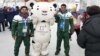 Muhammad Karim and Syed Human pose with Pyeongchang Olympics mascot.