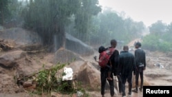 Des riverains observent les dégâts causés par le cyclone Freddy à Chilobwe, Blantyre, Malawi, le 13 mars 2023. 