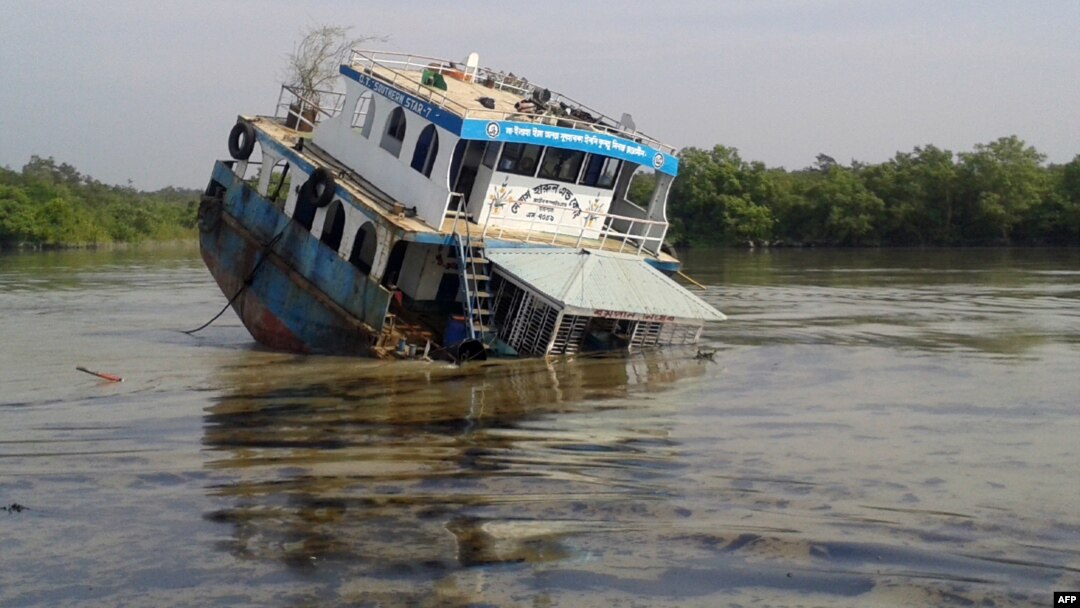 A Bangladeshi tanker lists in the Sela River in the Sundarbans, spreading oil that threatens the environment, Dec. 9, 2014.