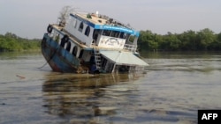 A Bangladeshi tanker lists in the Sela River in the Sundarbans, spreading oil that threatens the environment, Dec. 9, 2014.