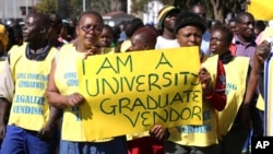 Zimbabwean vendors hold banners urging the government to stop their forced removals from the street during a demonstration in Harare, Wednesday, June, 24, 2015. Hundreds of vendors took to the streets of Harare demonstrating against an impending eviction from the streets, saying they will not move despite a Friday deadline to do so. (AP Photo/Tsvangirayi Mukwazhi)