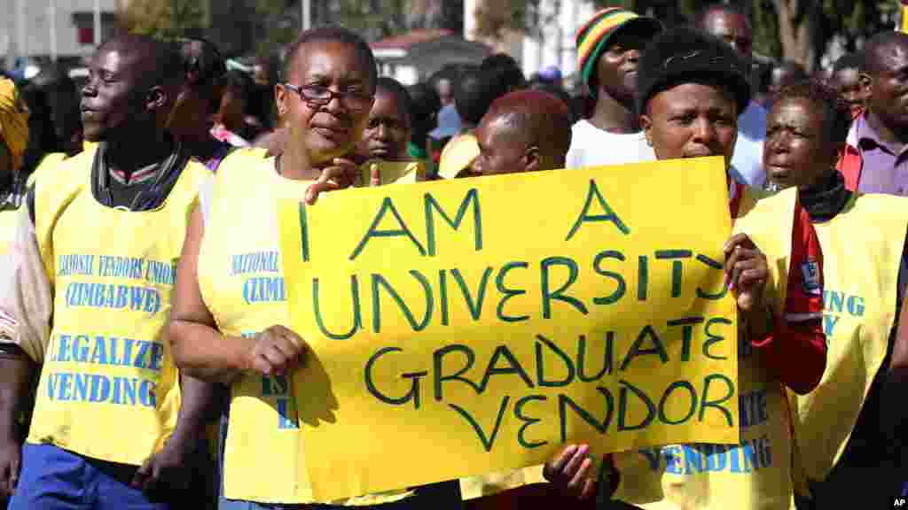 Zimbabwean vendors hold banners urging the government to stop their forced removals from the street during a demonstration in Harare, Wednesday, June, 24, 2015. Hundreds of vendors took to the streets of Harare demonstrating against an impending eviction from the streets.