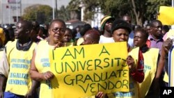 FILE: Zimbabwean vendors hold banners urging the government to stop their forced removals from the street during a demonstration in Harare, Wednesday, June, 24, 2015. Hundreds of vendors took to the streets of Harare demonstrating against an impending eviction from the streets, saying they will not move despite a Friday deadline to do so. (AP Photo/Tsvangirayi Mukwazhi)