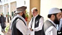 FILE - Pakistan's Foreign Minister Shah Mehmood Qureshi, center, receives members of Taliban delegation in Islamabad, Pakistan, Oct. 3, 2019. Senior Taliban leaders are meeting with Qureshi in Islamabad in a push to revive an Afghanistan peace deal.