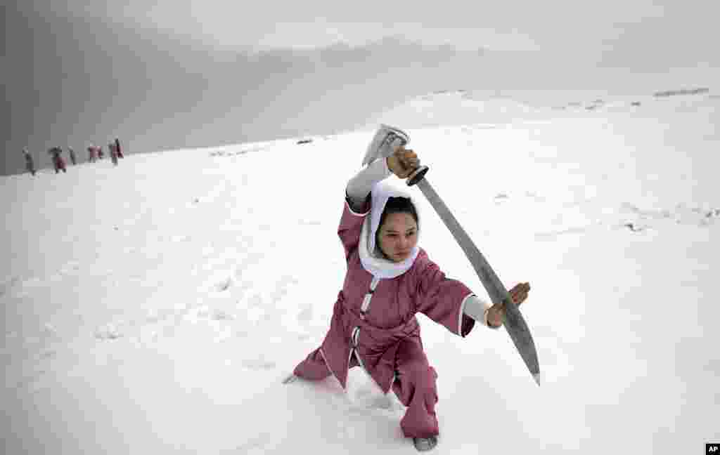 Seorang perempuan murid perguruan beladiri &#39;Shaolin&#39; melakukan latihan di puncak bukit yang bersalju di Kabul, Afghanistan.