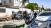 FILE - Cars destroyed in a rocket attack allegedly fired from the Gaza strip are seen through a damaged window of a house in the village of Arara in the Negev Desert, a place residents say is constantly hit by rockets, on Oct. 14, 2023.