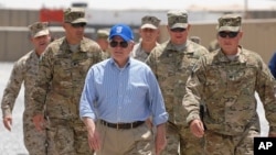 US Secretary of Defense Robert M. Gates walks with a group of service members at Forward Operating Base Waltman, Kandahar, Afghanistan, June 5, 2011