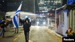 Security forces use a water cannon to disperse the people attending a demonstration against Israeli Prime Minister Benjamin Netanyahu and his nationalist coalition government's plan for judicial overhaul, in Tel Aviv, Israel, March 27, 2023.