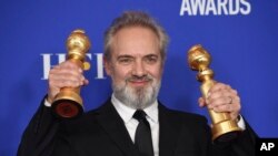 Sutradara film "1917", Sam Mendes, mengangkat piala Golden Globe untuk sutradara terbaik dan film drama terbaik dalam Penghargaan Golden Globe ke-77 di Beverly Hilton Hotel, Minggu, 5 Januari 2020. (Foto: AP)