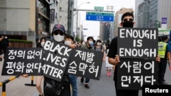 FILE - People march on the street in solidarity with protests against the death in Minneapolis police custody of George Floyd, in Seoul, South Korea, June 6, 2020. 