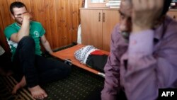 Rođaci nastradlog deteta u prostoriji sa njegovim posmrtnim ostacima u džamiji u selu Duma na Zapadnoj Obali