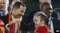 Pangeran Felipe dari Spanyol (kiri) merayakan kemenangan tim matador dalam Piala Eropa bersama Andres Iniesta (kanan) (foto: 2/7). Iniesta dinobatkan sebagai pemain terbaik kejuaraan Eropa.