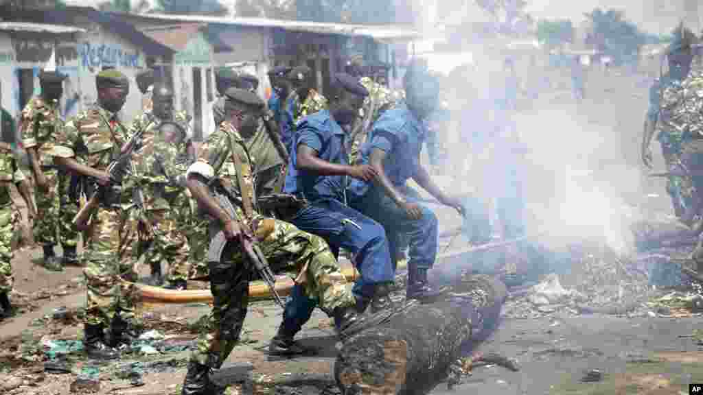 Des policiers et des militaires enlèvent des barricades dressées par des manifestants de l'opposition dans le quartier de Cibitoke de la capitale Bujumbura, 25 mai 2015. 