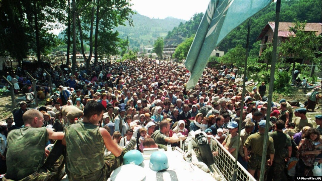 Fotografija od četvrtka, 13. jula 1995. godine, prikazuje holandske mirovne snage UN-a kako sjede na oklopnom transporteru dok se muslimanske izbjeglice iz Srebrenice, istočna Bosna, okupljaju u selu Potočari