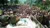 FILE - A Thursday July 13, 1995 photo from files showing Dutch UN peacekeepers sitting on top of an APC while Muslim refugees from Srebrenica, eastern Bosnia, gather in the village of Potocari