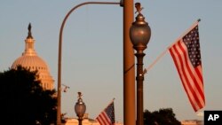 Flags fly at sunset with 51 instead of the usual 50 stars, along Pennsylvania Ave., part of a display in support of statehood for the District of Columbia, Sept. 15, 2019, in Washington.