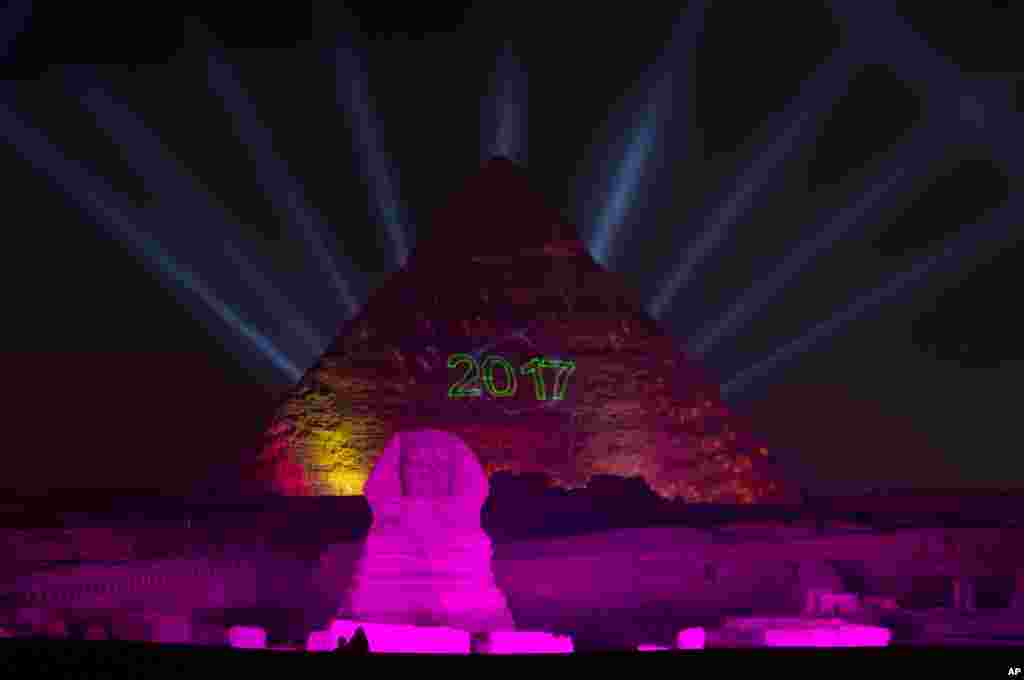 Lampu menerangi situs bersejarah Piramida Giza dan Sphinx dalam perayaan Tahun Baru di Mesir, 1 Januari 2017.