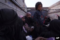 FILE - A child stands on the back of a truck after being evacuated out of the last territory held by Islamic State militants, outside Baghuz, Syria, March 4, 2019.