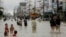 People walk in a flooded street at Muang district in Nakhon Si Thammarat Province, southern Thailand, Jan. 6, 2017. 