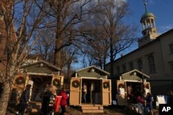 People shop at Christmas-themed wooden huts located next to the Central Moravian Church in Bethlehem, Pennsylvania, Dec. 1, 2024.