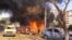 This photo released by the Syrian official news agency SANA, shows flames and smoke rising from burned cars after a huge explosion that shook central Damascus,February 21, 2013. 