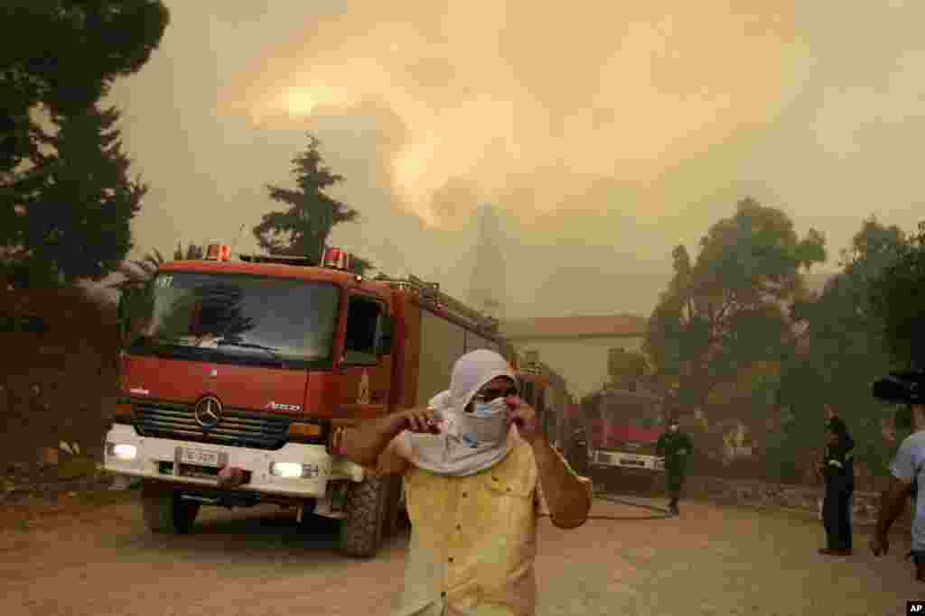 Local residents and firefighters try to save Galataki Monastery as a fire approaches the area near the seaside village of Limni on the island of Evia, about 160kilometers (100 miles) north of Athens, Greece.