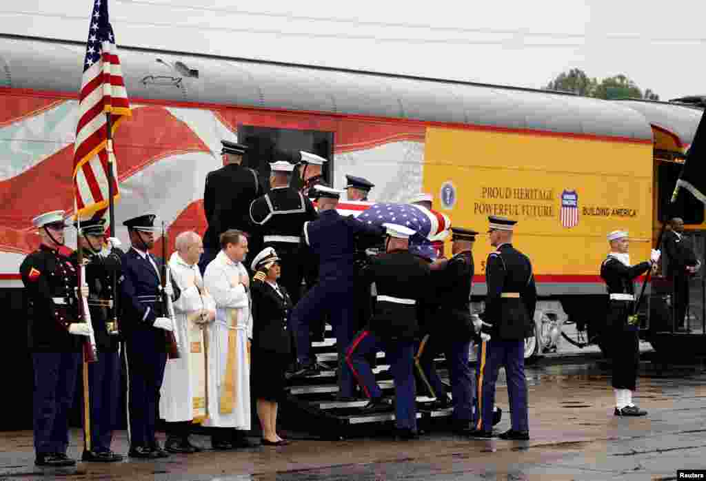 The flag-draped casket of former President George H.W. Bush is carried by a joint services military honor guard in Spring, Texas, as it is placed on a Union Pacific train. The train will take about 2 hours to travel roughly 70 miles (113 kilometers) to the city of College Station, home to Bush&#39;s presidential library at Texas A&amp;M University. The locomotive has been painted the colors of the Air Force One plane used during his presidency and bears the number &quot;4141&quot; in honor of the 41st president. &nbsp; &nbsp;