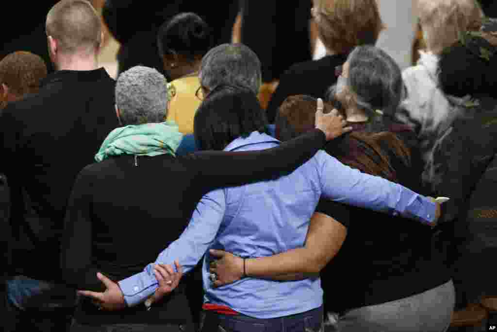 Family members embrace each other as they hold a vigil for victims of the shooting at Sandy Hook Elementary School in Newtown, Conn., and other victims of gun violence, Dec. 12, 2013.