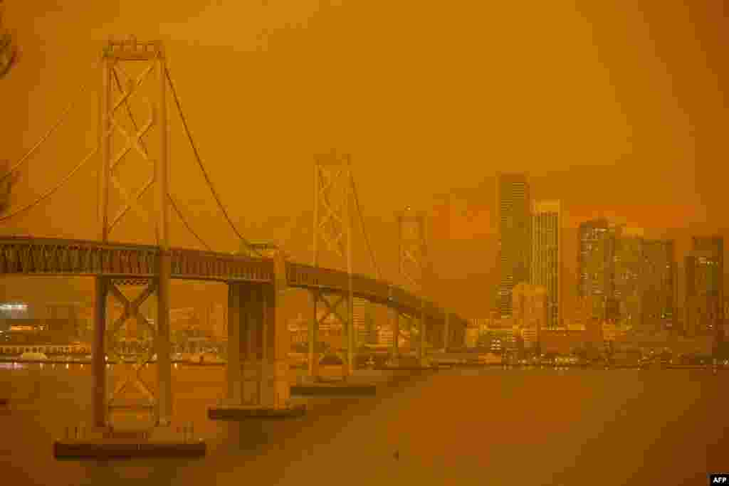 The San Francisco Bay Bridge and city skyline are obscured in orange smoke and haze as seen from Treasure Island in San Francisco, California, Sep. 9, 2020.