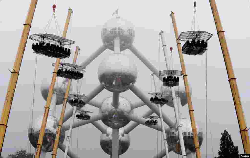 Ten tables, accommodating a total of 220 guests, are suspended from cranes at a height of 40 meters in front of the Atomium, a 102-meter (335 feet) high structure and its nine spheres, built for the 1958 Brussels World&#39;s Fair, as part of the 10th anniversary of the event known as &quot;Dinner in the Sky&quot;, in Brussels, Belgium, June 1, 2016.