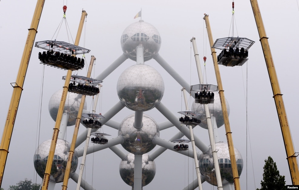 Ten tables, accommodating a total of 220 guests, are suspended from cranes at a height of 40 meters in front of the Atomium, a 102-meter (335 feet) high structure and its nine spheres, built for the 1958 Brussels World&#39;s Fair, as part of the 10th anniversary of the event known as &quot;Dinner in the Sky&quot;, in Brussels, Belgium, June 1, 2016.