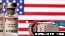 Botol berlabel "VAKSIN Coronavirus COVID-19" dan jarum suntik terlihat di depan bendera AS yang dipajang dalam ilustrasi ini diambil 11 Desember 2021. (Foto: REUTERS/Dado Ruvic)