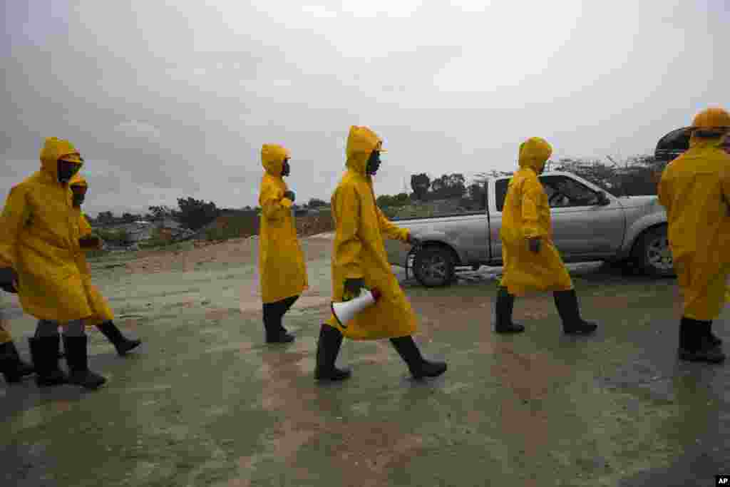 Civil protection workers walk in to evacuate residents from the Grise river area, prior the arrival of Hurricane Matthew, in Tabarre, Haiti, Oct. 3, 2016. The center of Hurricane Matthew is expected to pass near or over southwestern Haiti on Tuesday, but the area is already experiencing rain from the outer bands of the storm.