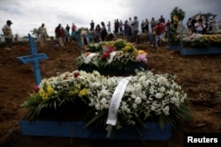 Flowers are left by relatives during the funeral of one of the inmates who died during a prison riot, at the Taruma cemetery in Manaus, Brazil, Jan. 4, 2017.