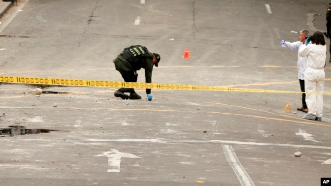 Policía e investigadores inspeccionan el sitio donde una bomba casera explotó cerca de la plaza de toros de Santamaría en Bogotá, Colombia, el domingo 19 de febrero de 2017.