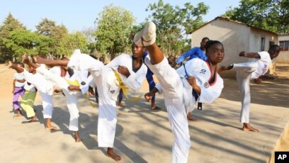 Natsiraishe Maritsa, second right, goes through taekwondo kicking drills during a practice session with young boys and girls in the Epworth settlement about 15 km southeast of the capital Harare, Saturday Nov. 7, 2020.