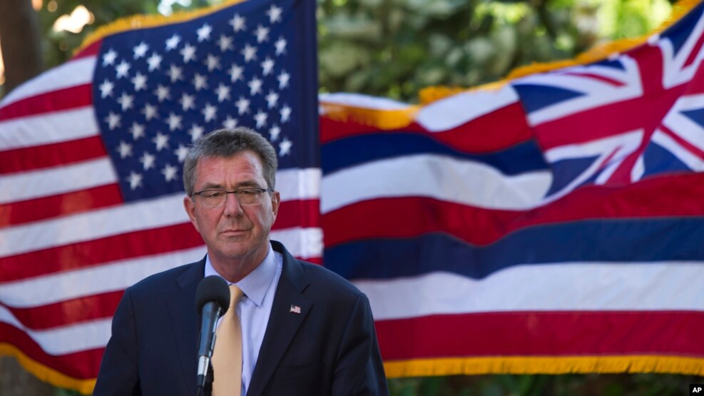 With the U.S. and Hawaii flags fluttering in the background, Defense Secretary Ash Carter speaks at a press conference during a defense ministers meeting of ASEAN, in Hawaii.