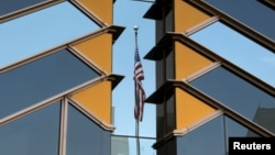 FILE - The U.S. flag is reflected on the windows of the U.S. Embassy in Kabul, Afghanistan, July 30, 2021. 