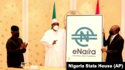 Nigerian President Muhammadu Buhari, center, and Central Bank governor Godwin Emefiele, right, launch digital currency eNaira in Abuja, Oct. 25, 2021.